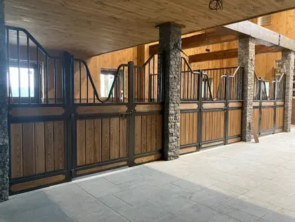 Installation de façades de box pour chevaux haut de gamme Equinad avec boiserie et acier galvanisé.